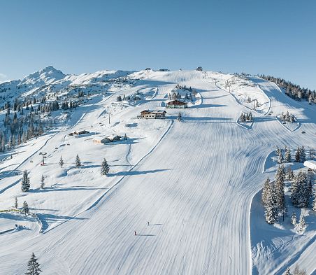 Eine Drohnenaufnahme vom Skigebiet Snow Space Salzburg in Flachau mit Pisten, Bergen und Liften.