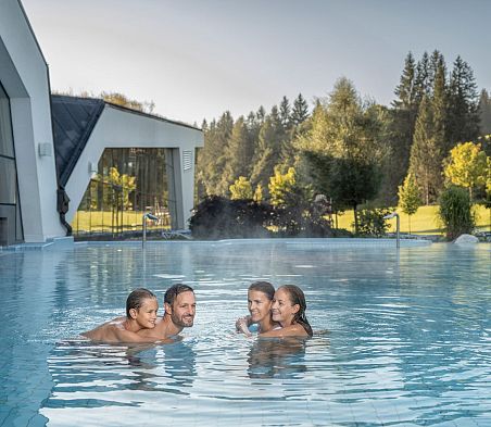 Vier Personen im Außenpool der Erlebnis-Therme Amadé, SalzburgerLand.