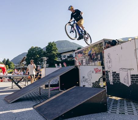Mountainbike-Show mit Sprungrampe vor Publikum beim E-Festival in Flachau, Österreich.