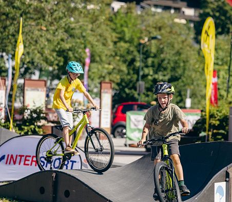 Kinder fahren mit dem Bike über den Pumptrack in Flachau, Salzburger Land.