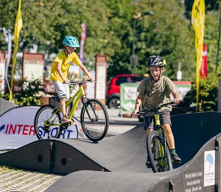 Kinder fahren mit dem Bike über den Pumptrack in Flachau, Salzburger Land.