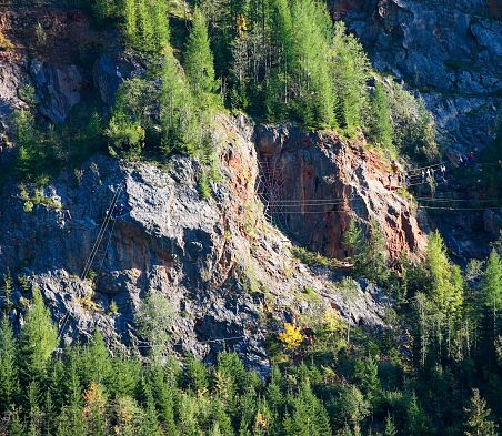 Klettersteig  an einer Felswand in der Umgebung von Flachau im SalzburgerLand mit mehreren Personen.