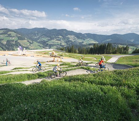 Kinder toben sich auf den Trails der woom bike area aus.