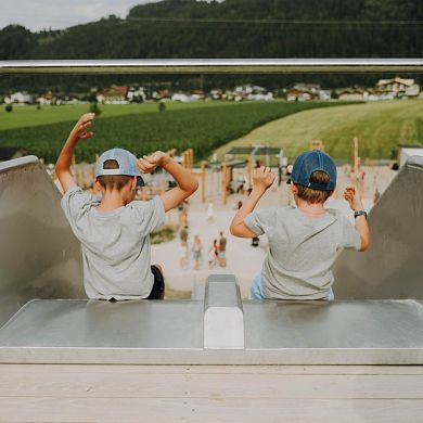 Zwei Kinder starten auf der Hangrutsche im Erlebnispark FUNSPACE Flachau.