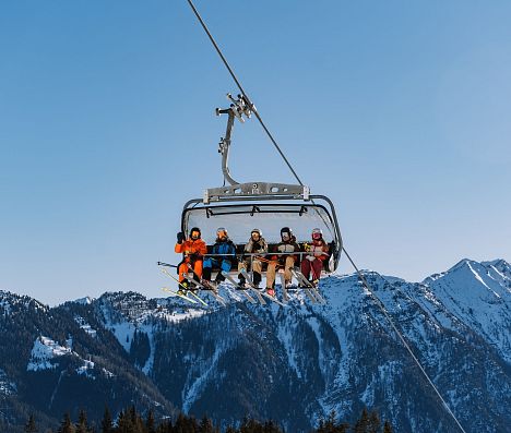 Fünf Skifahrer in Sessellift in Flachau