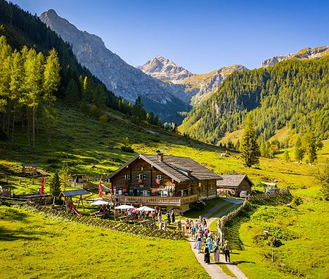 Vordere Marbachalm in Flachau im SalzburgerLand mit Wanderern und Bergkulisse.