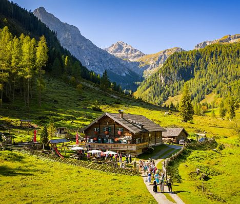 Vordere Marbachalm in Flachau im SalzburgerLand mit Wanderern und Bergkulisse.