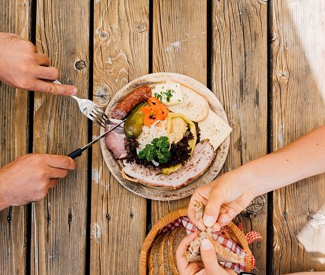 Brettljause mit Käse, Wurst und Brot auf Holztisch im Salzburger Land.