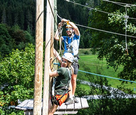 Junge Outdoorsportlerin und Guide am Hochseilgarten in Flachauwinkl.