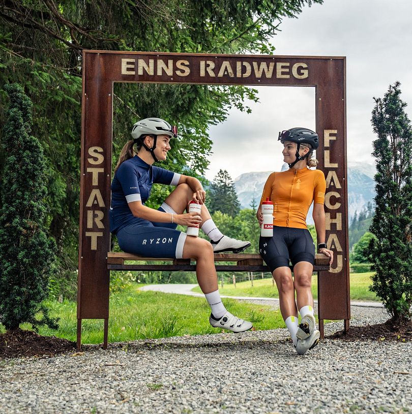 Radfahrerinnen pausieren am Startpunkt des Ennsradwegs in Flachau, Salzburger Land