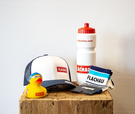 Flachau Fanshop-Artikel Badeente, Kappe, Socken und Trinkflasche im beliebten Flachau-Design.
