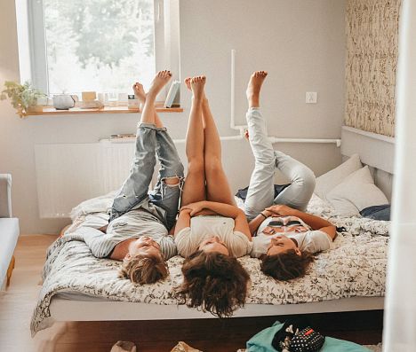 Mutter und Kids liegen gemütlich im Bett und genießen ihren Urlaub in Flachau