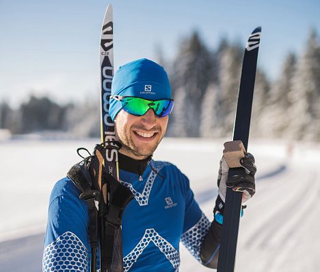 Langläufer lacht in die Kamera, sonniger Wintertag, Flachau.