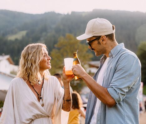 Paar stößt bei E-Festival Flachau 2025 im Salzburger Land, Österreich, fröhlich an