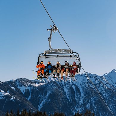 Fünf Skifahrer in Sessellift in Flachau