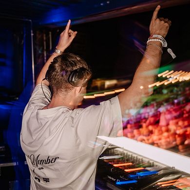 DJ mit Kopfhörern heizt die Stimmung beim E-Festival in Flachau, Salzburger Land an.