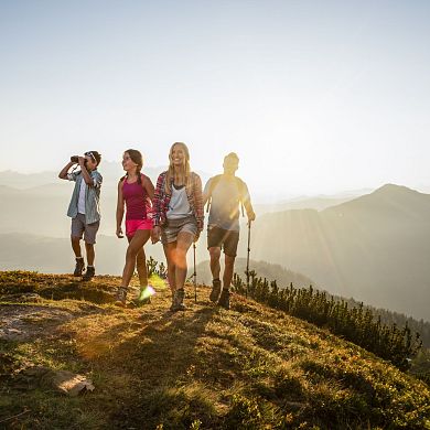 Eine Familie beim Aufstieg aufs Grießenkar in Flachau. Der Sohn erkundet mit dem Fernglas die Bergwelt.