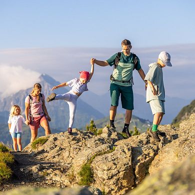 Familie wandert über einen felsigen Bergweg in Flachau – ideal für einen aktiven Familienurlaub im Sommer.