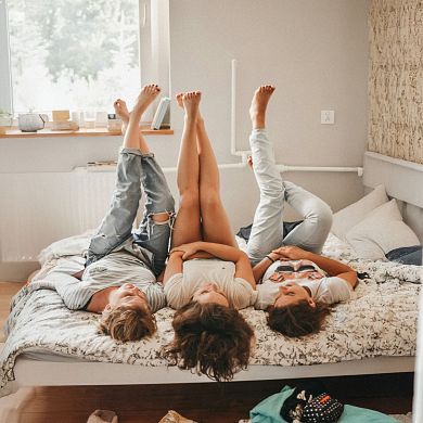 Mutter und Kids liegen gemütlich im Bett und genießen ihren Urlaub in Flachau