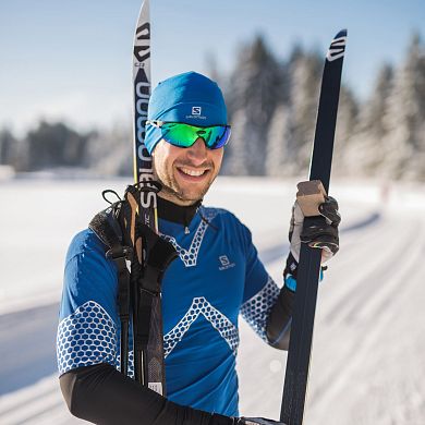Langläufer lacht in die Kamera, sonniger Wintertag, Flachau.